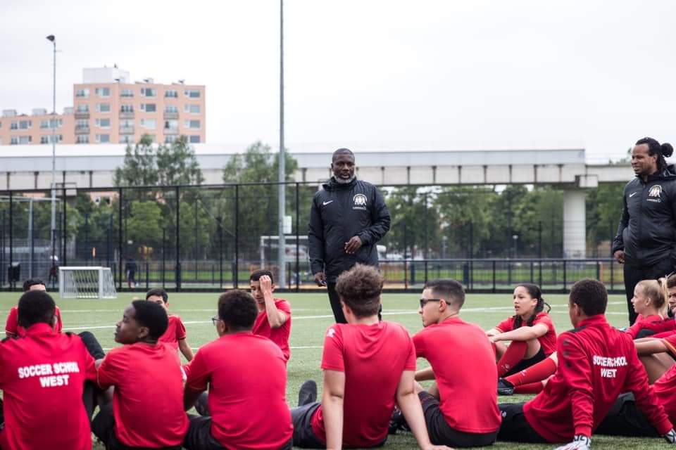 Coaches van Stichting SSW begeleiden jongeren tijdens een sessie op het voetbalveld
