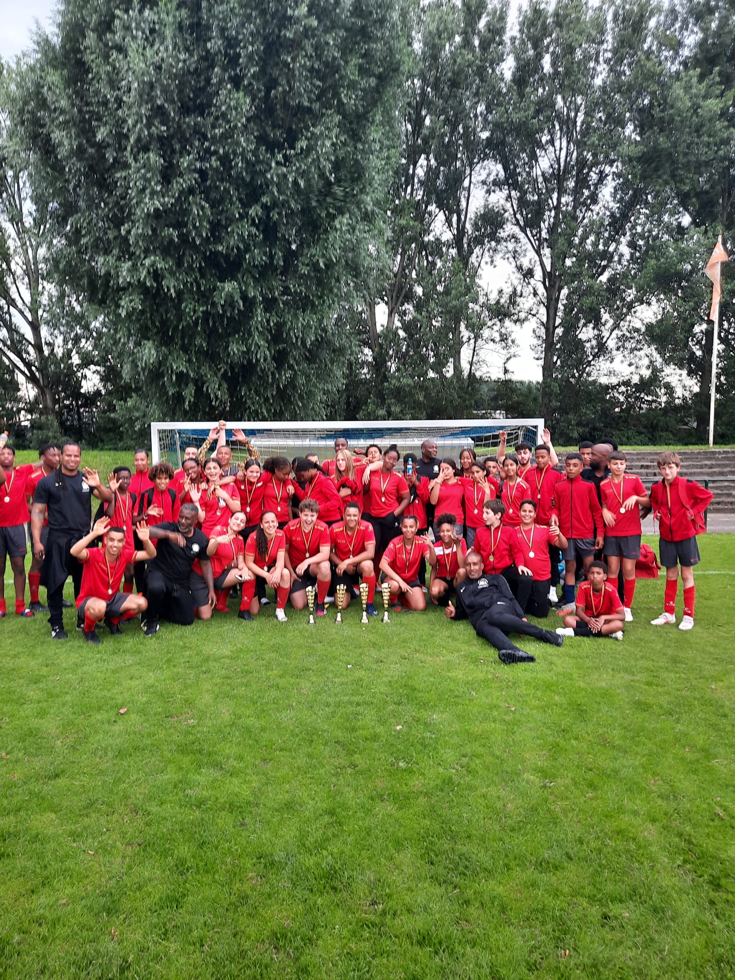 Team van Stichting SSW viert succes met medailles en bekers op het voetbalveld